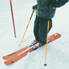Skier standing with orange Faction poles